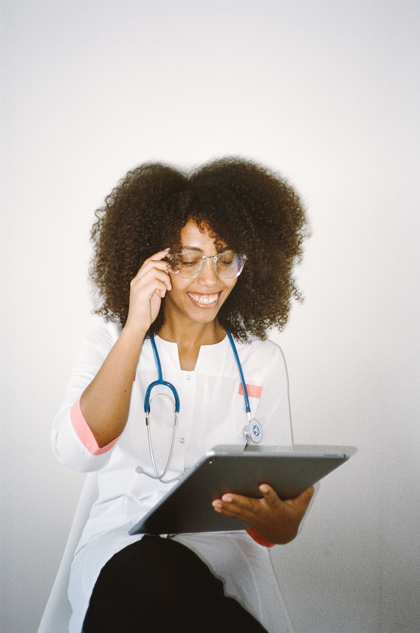 A smiling healthcare professional holding a tablet