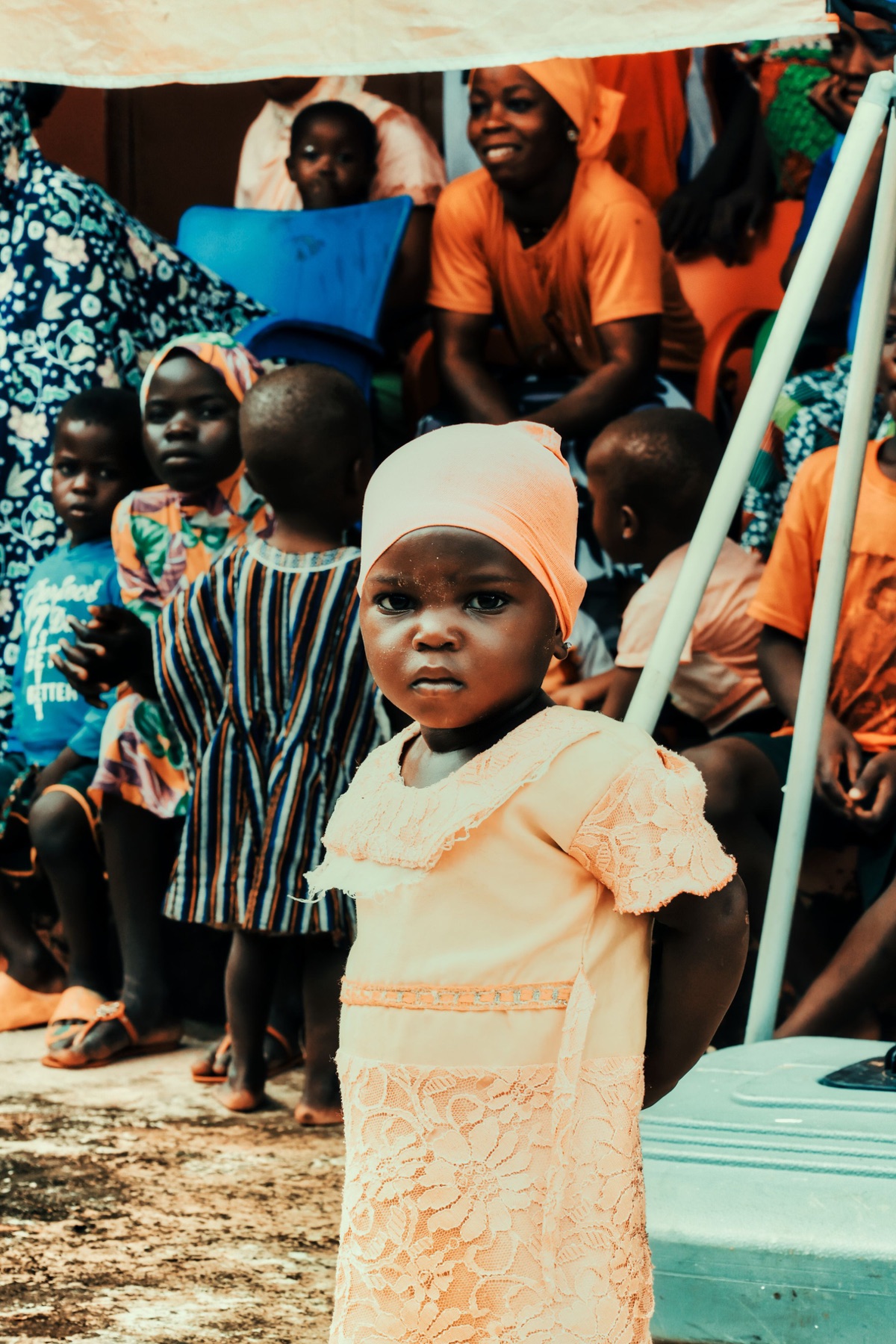 A child standing among other children in a community gathering